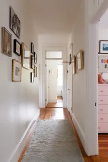 a view of a hallway with paintings on the wall