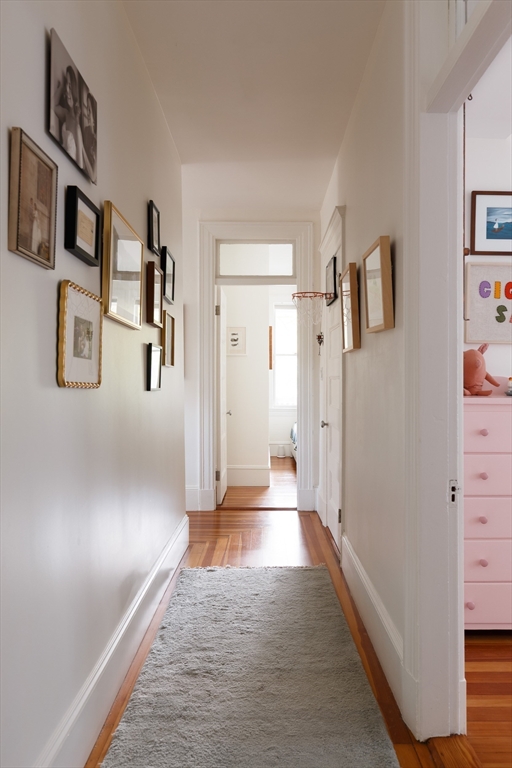 465 Huron Avenue, Unit 1 Cambridge, MA 02138 - Photo 15 of 23 a view of a hallway with paintings on the wall