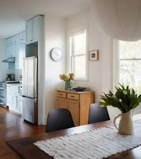a kitchen with stainless steel appliances granite countertop a refrigerator table and chairs