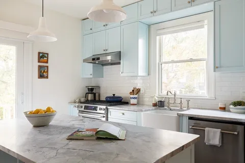a kitchen with sink a stove and cabinets