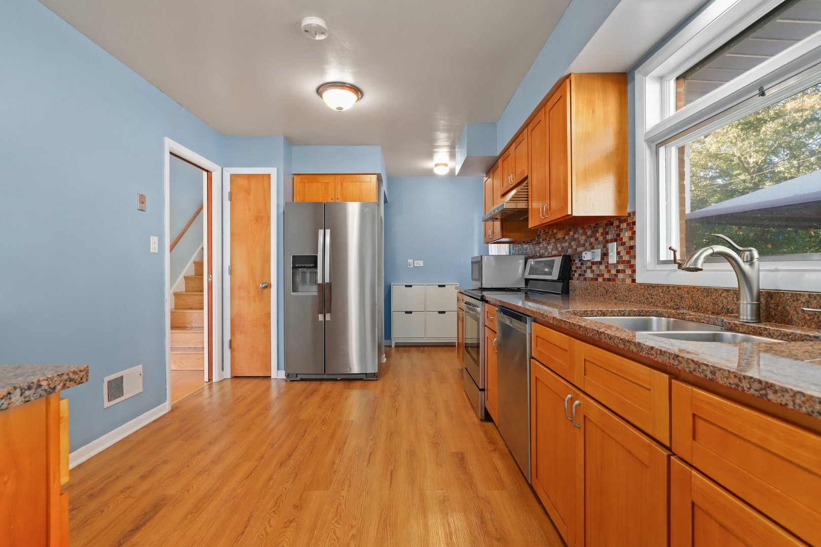 410 Ferndale Road Glenview, IL 60025 - Photo 11 of 34 a kitchen with stainless steel appliances granite countertop a refrigerator a sink and wooden floors
