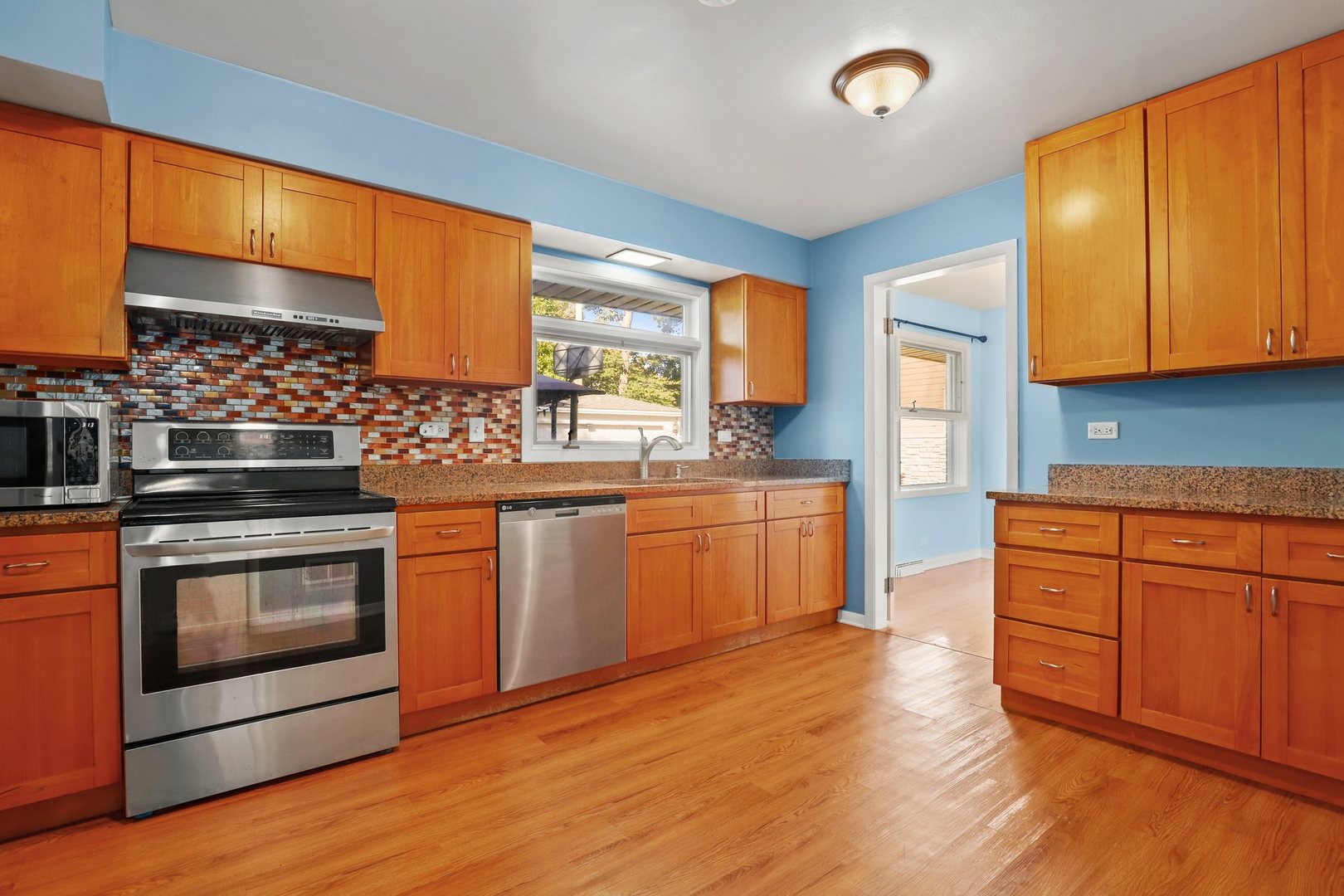 410 Ferndale Road Glenview, IL 60025 - Photo 9 of 34 a kitchen with stainless steel appliances granite countertop wooden cabinets a sink a stove a refrigerator and island with wooden floor