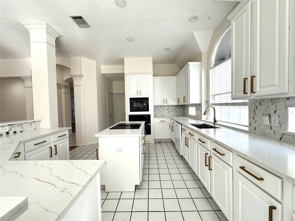 10305 Open Gate Drive Austin, TX 78726 - Photo 12 of 25 a kitchen with stainless steel appliances kitchen island granite countertop a sink and a stove