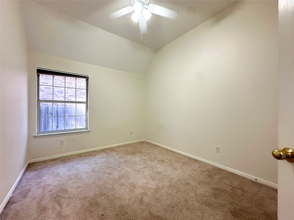 10305 Open Gate Drive Austin, TX 78726 - Photo 22 of 25 an empty room with a chandelier fan and windows