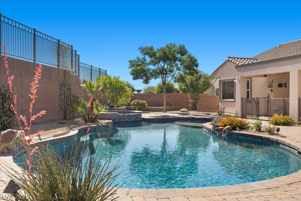 2125 De Rouge Avenue Henderson, NV 89044 - Photo 78 of 96 A tranquil oasis awaits with this sparkling pool and integrated spa, perfect for relaxation and recreation.
