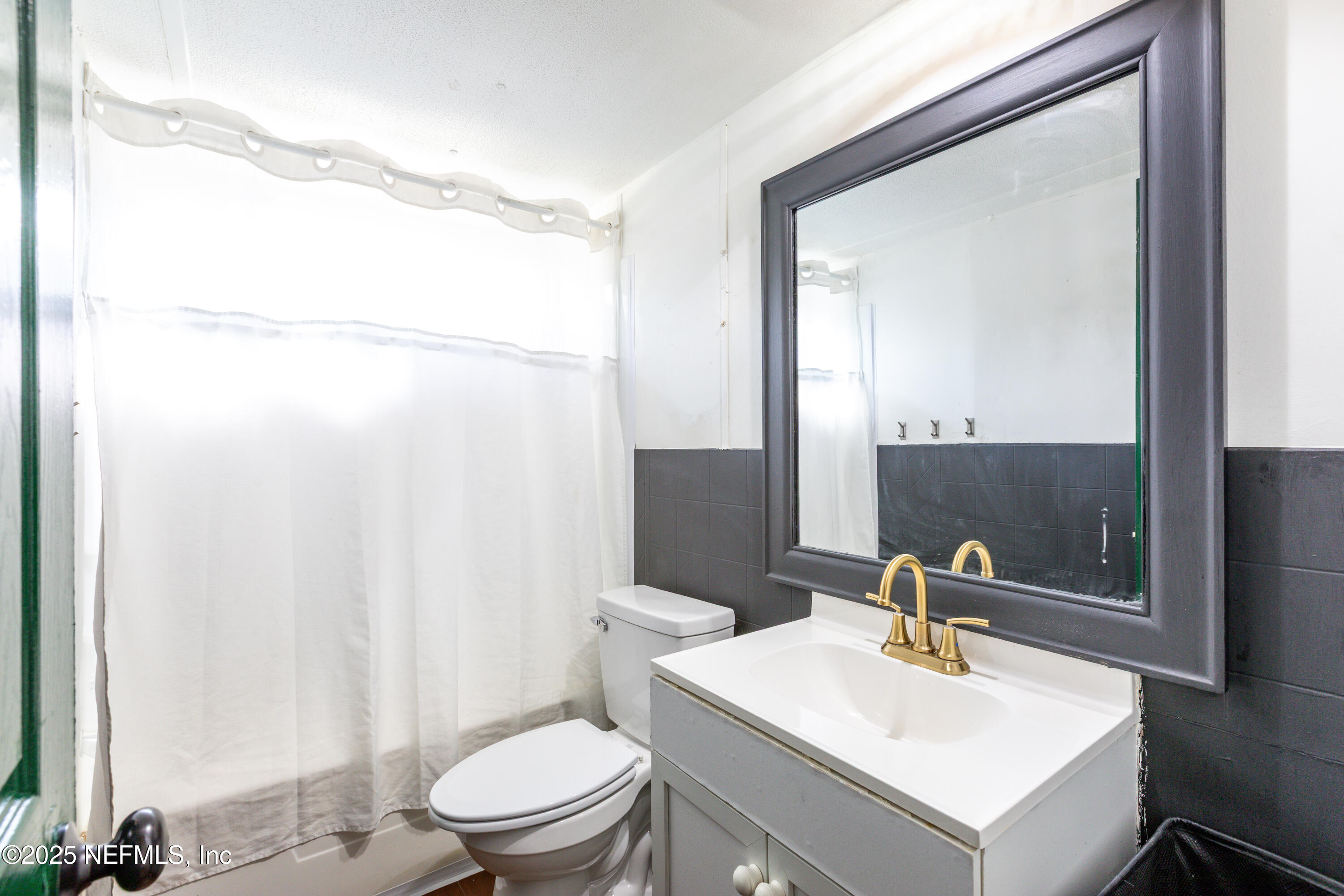 6336 Bucknell Avenue Keystone Heights, FL 32656 - Photo 14 of 18 a bathroom with a sink a toilet and a mirror