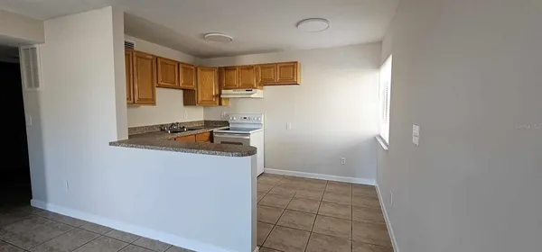 a kitchen with granite countertop a refrigerator and a stove top oven
