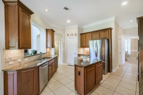 a kitchen with stainless steel appliances granite countertop a refrigerator and a stove