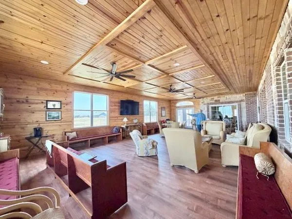 a living room with furniture lots of wooden floor