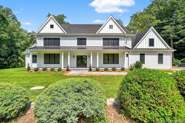 a front view of a residential houses with yard and green space
