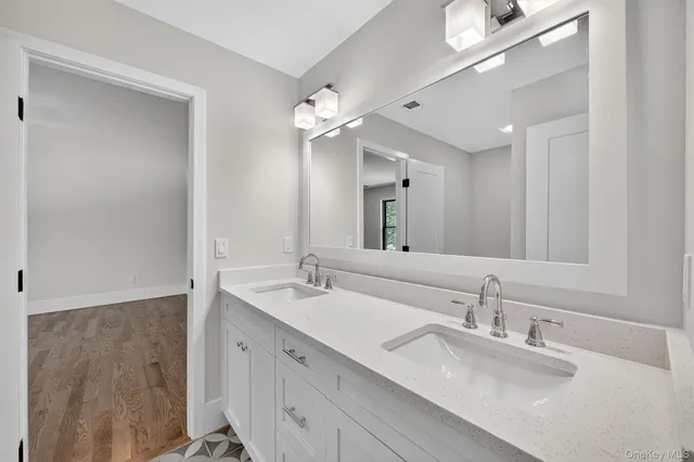 a bathroom with a double vanity sink and a mirror