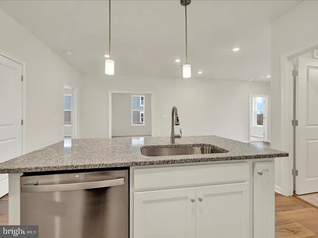 a kitchen with granite countertop a sink a counter space and cabinets
