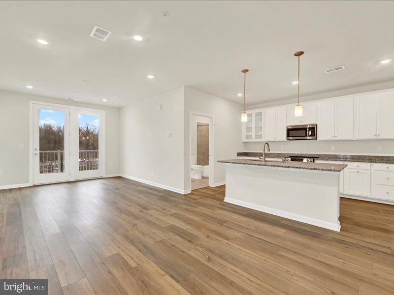 4003 Seaside Alder Road, Unit 307 HOLLY Bowie, MD 20720 - Photo 2 of 28 a view of kitchen with granite countertop refrigerator oven a stove top oven with wooden floor