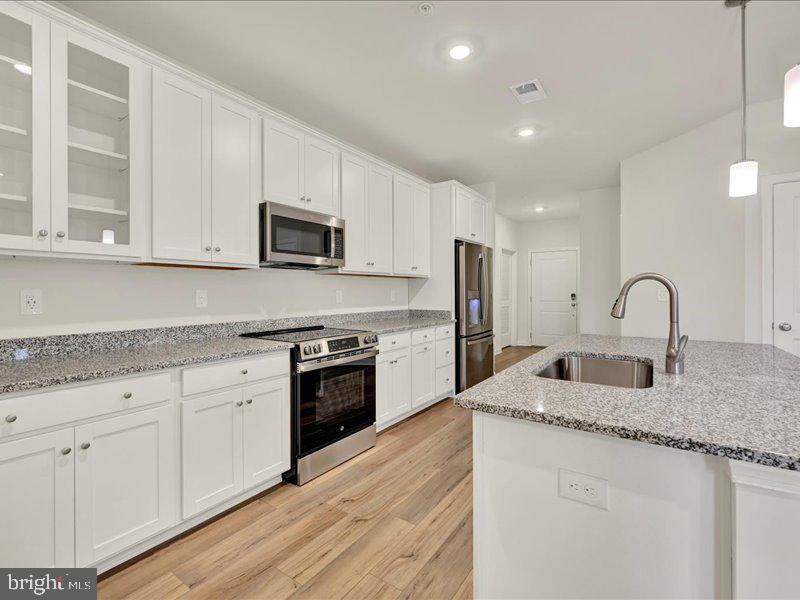4003 Seaside Alder Road, Unit 307 HOLLY Bowie, MD 20720 - Photo 7 of 28 a kitchen with granite countertop white cabinets and stainless steel appliances