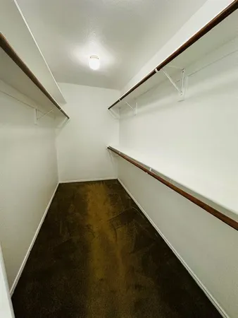 a view of a room with wooden floor ceiling fan and window