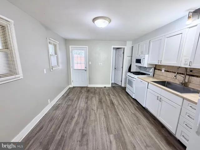 a kitchen with cabinets wooden floor and a sink