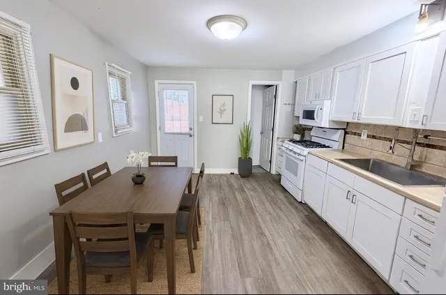 a kitchen with a table chairs sink and cabinets