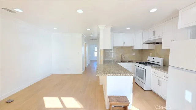 a kitchen with a stove a sink and a refrigerator