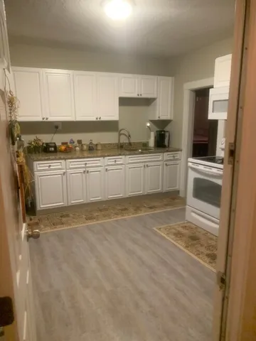 a kitchen with granite countertop a sink and cabinets