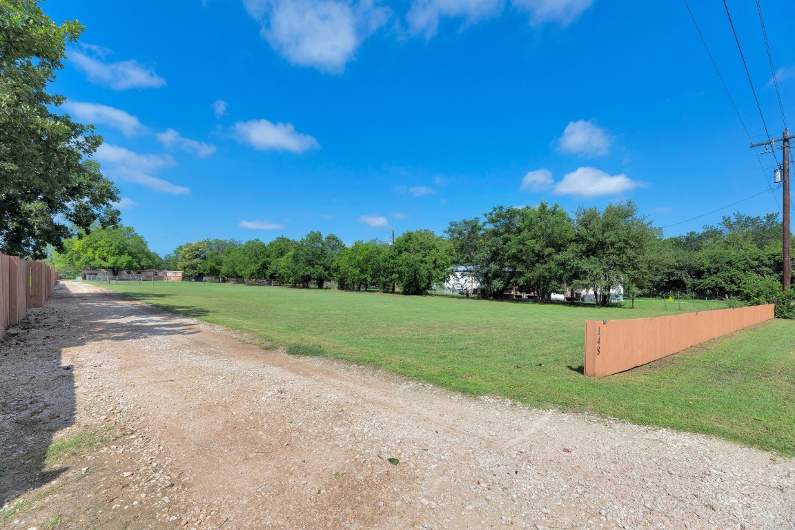 148 Meadows Drive Elgin, TX 78621 - Photo 11 of 38 a view of a field with grass and a building