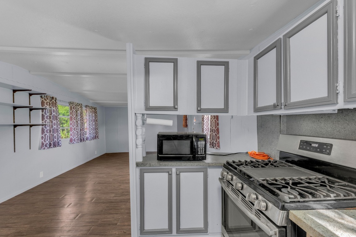 148 Meadows Drive Elgin, TX 78621 - Photo 13 of 38 a kitchen with granite countertop stainless steel appliances a stove cabinets and microwave