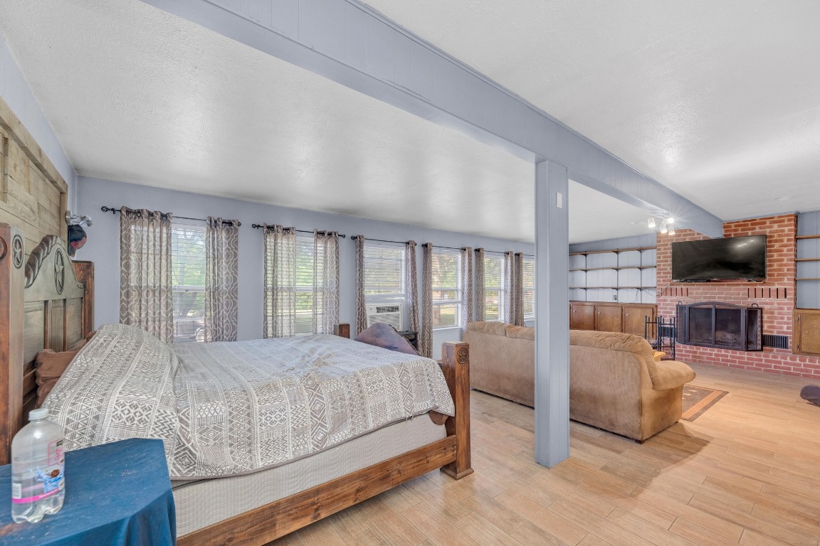 148 Meadows Drive Elgin, TX 78621 - Photo 17 of 38 a bedroom with a large bed a flat tv screen and a large window with the outer view