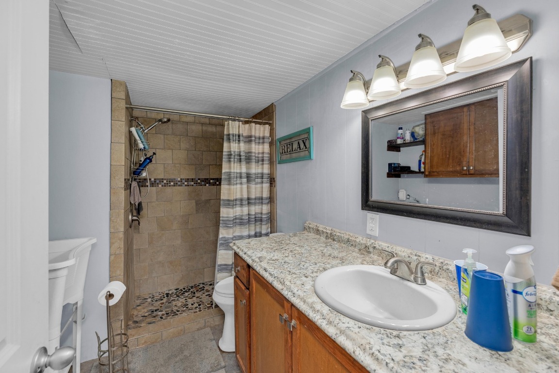 148 Meadows Drive Elgin, TX 78621 - Photo 25 of 38 a bathroom with a granite countertop sink toilet and shower