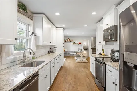a kitchen with stainless steel appliances granite countertop a sink stove and refrigerator