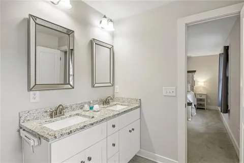 a bathroom with a granite countertop sink and a mirror