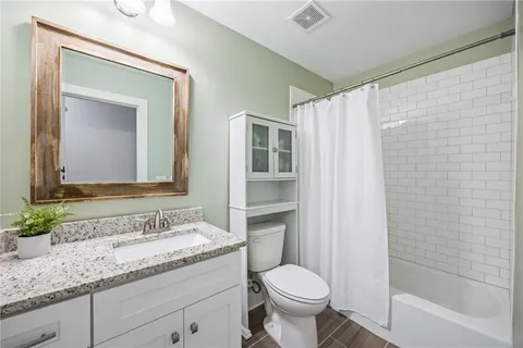 a bathroom with a granite countertop sink toilet and shower
