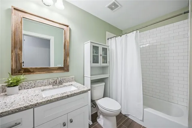 a bathroom with a granite countertop sink toilet and shower