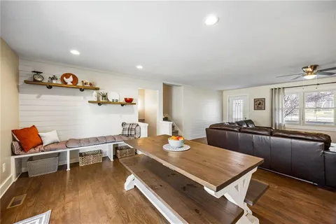 a living room with furniture stove and wooden floor