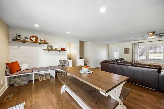 a living room with furniture stove and wooden floor