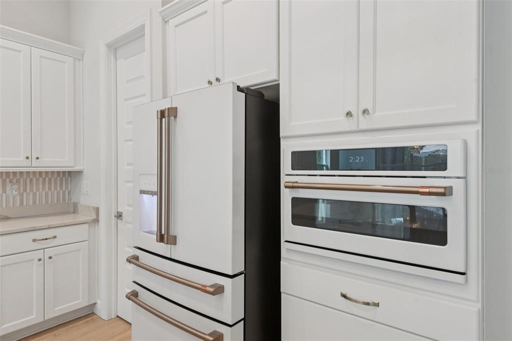 2304 Clement Road Lutz, FL 33549 - Photo 8 of 37 a kitchen with white cabinets and white appliances
