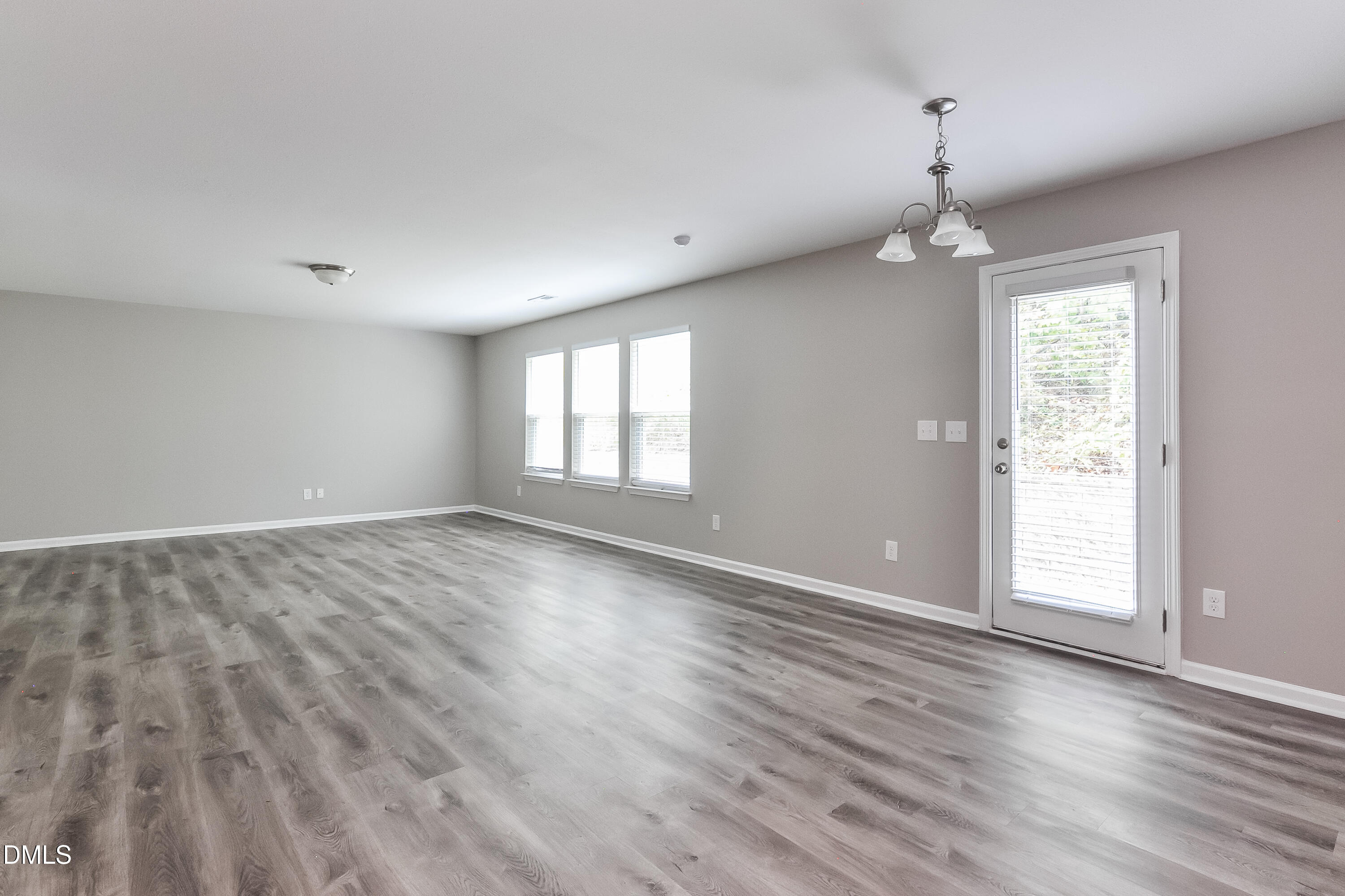 817 Leatherstone Lane Fuquay-Varina, NC 27526 - Photo 4 of 17 an empty room with wooden floor and windows