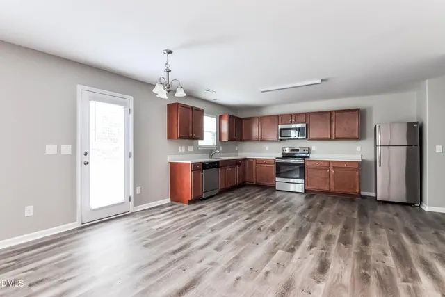 a view of kitchen with granite countertop cabinets and refrigerator