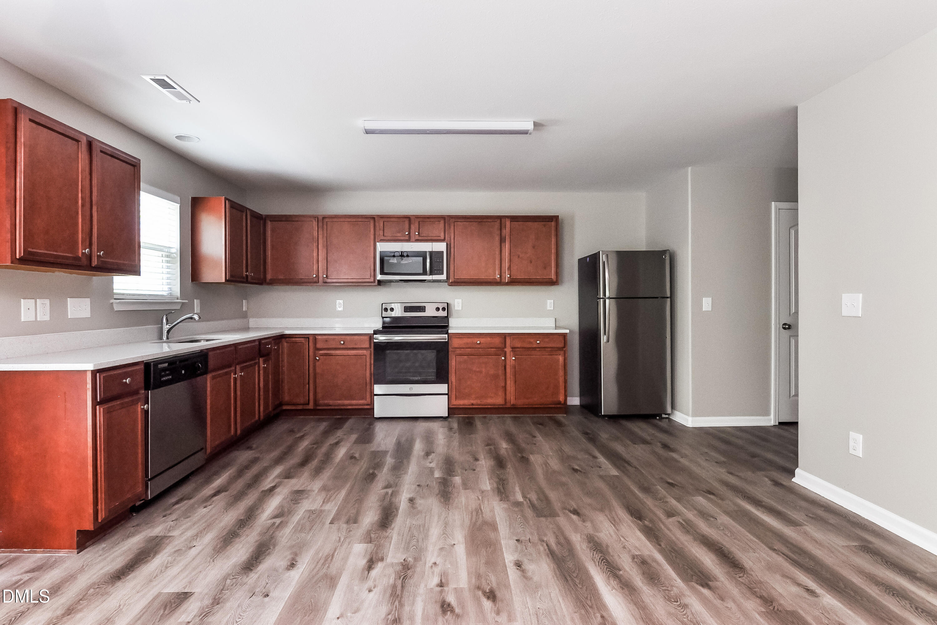 817 Leatherstone Lane Fuquay-Varina, NC 27526 - Photo 6 of 17 a kitchen with a refrigerator a stove top oven a sink and dishwasher with wooden floor