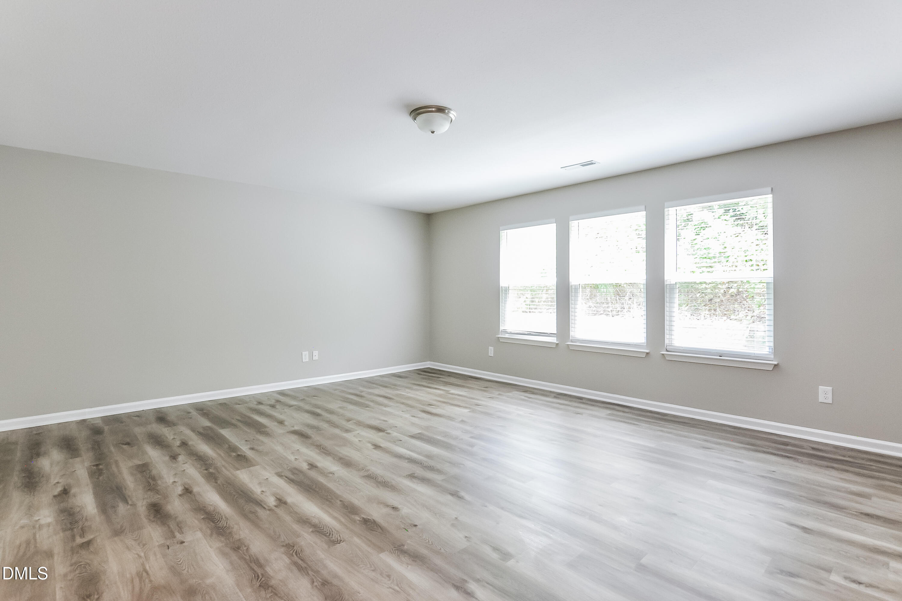 817 Leatherstone Lane Fuquay-Varina, NC 27526 - Photo 8 of 17 an empty room with wooden floor and windows