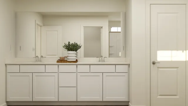 a bathroom with white cabinets and a sink