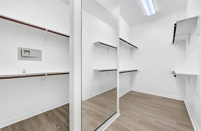 a view of a room with wooden floor and a ceiling fan