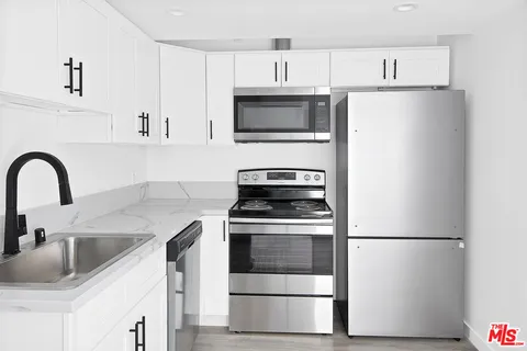a kitchen with stainless steel appliances a refrigerator sink and cabinets