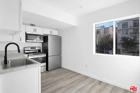 a kitchen with granite countertop a refrigerator and a sink