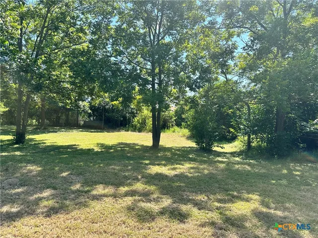 a view of yard with swimming pool and seating space