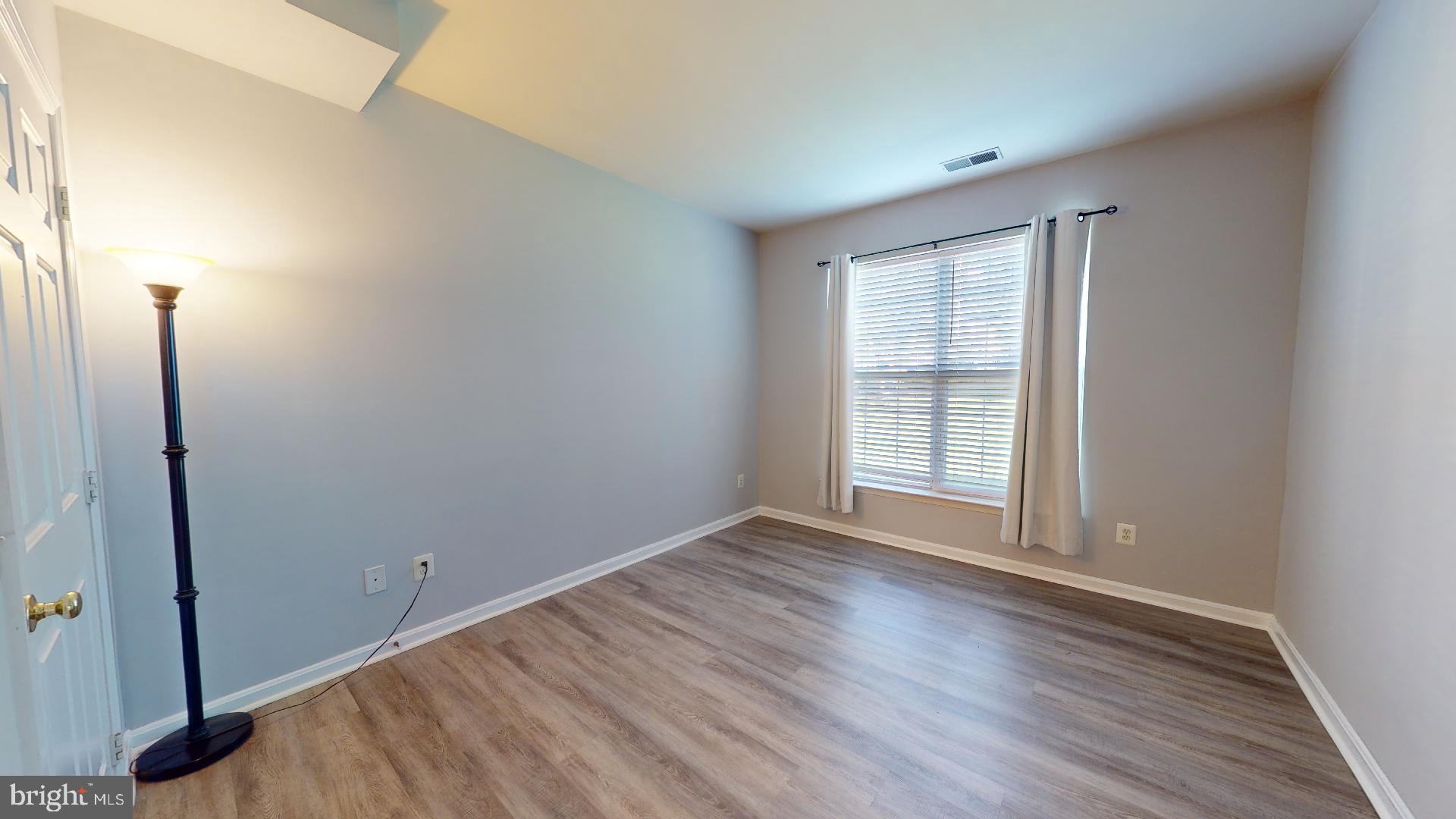 5947 Founders Hill Drive, Unit 103 Alexandria, VA 22310 - Photo 11 of 19 a view of an empty room with wooden floor and a window