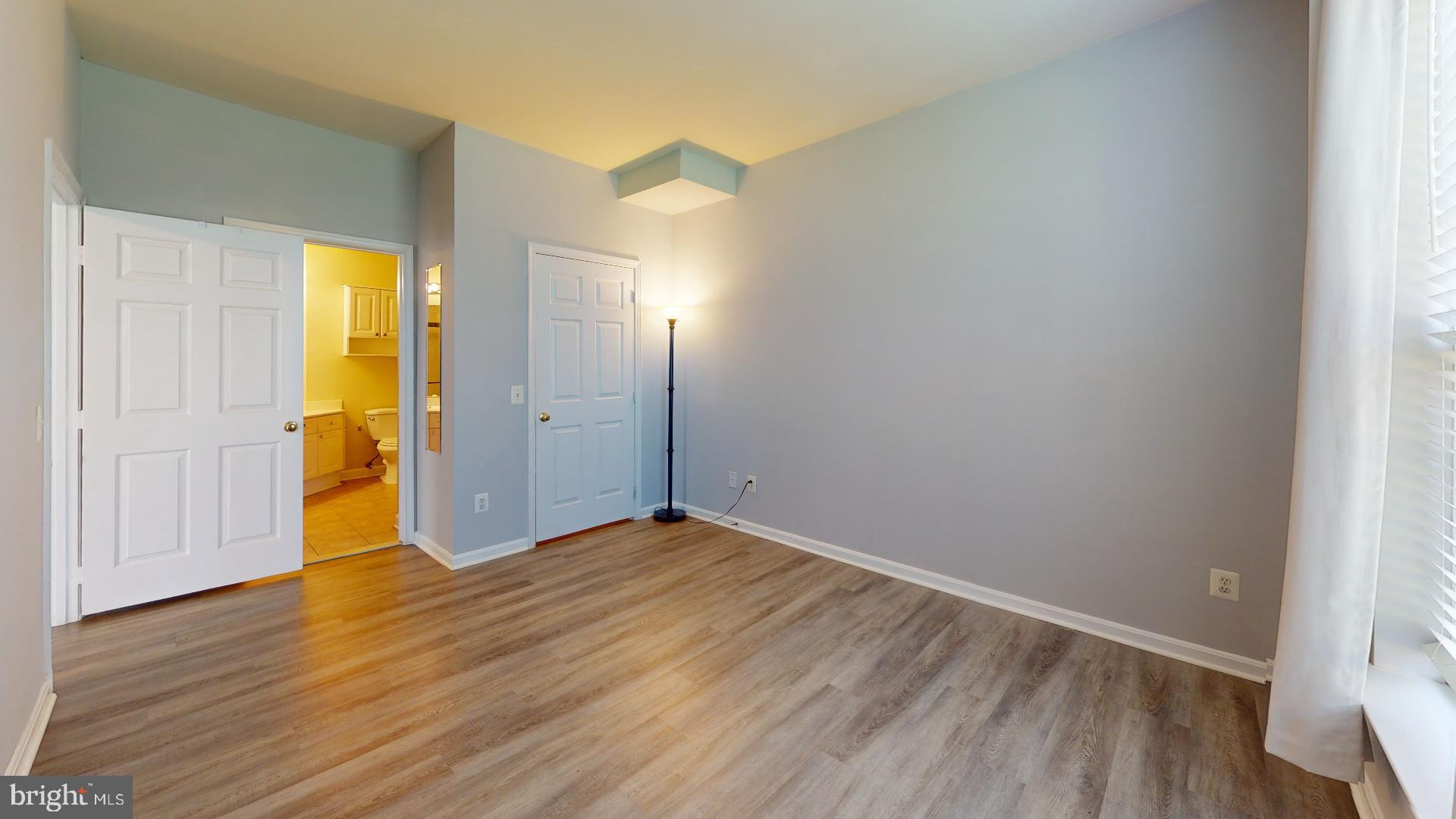 5947 Founders Hill Drive, Unit 103 Alexandria, VA 22310 - Photo 12 of 19 a view of an empty room with wooden floor and a window
