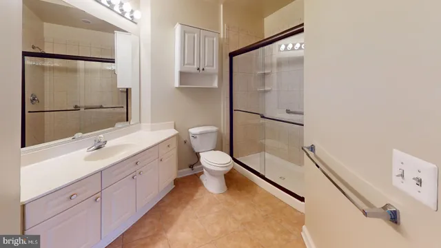 a bathroom with a double vanity sink toilet mirror and shower