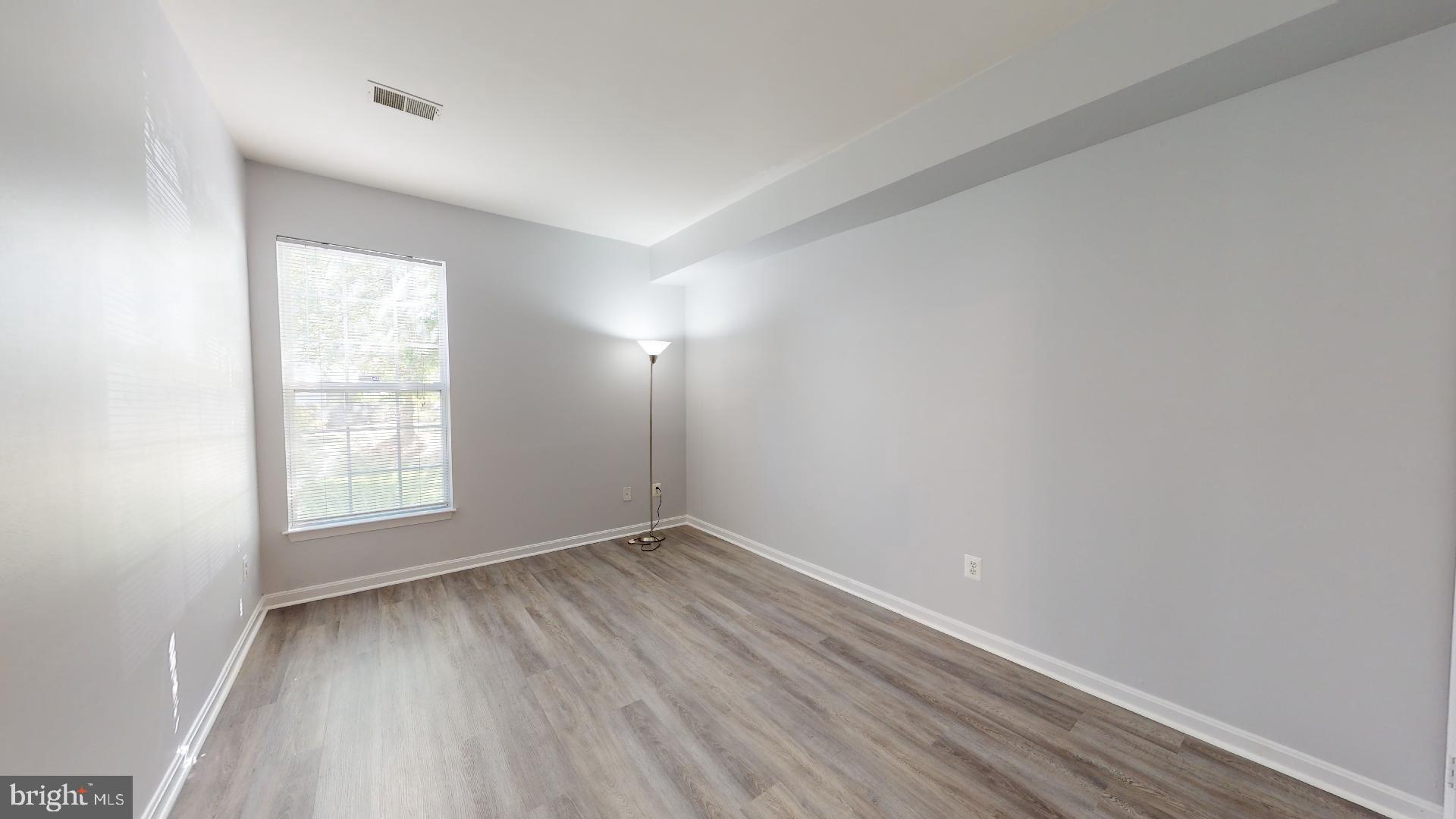 5947 Founders Hill Drive, Unit 103 Alexandria, VA 22310 - Photo 17 of 19 an empty room with wooden floor and windows