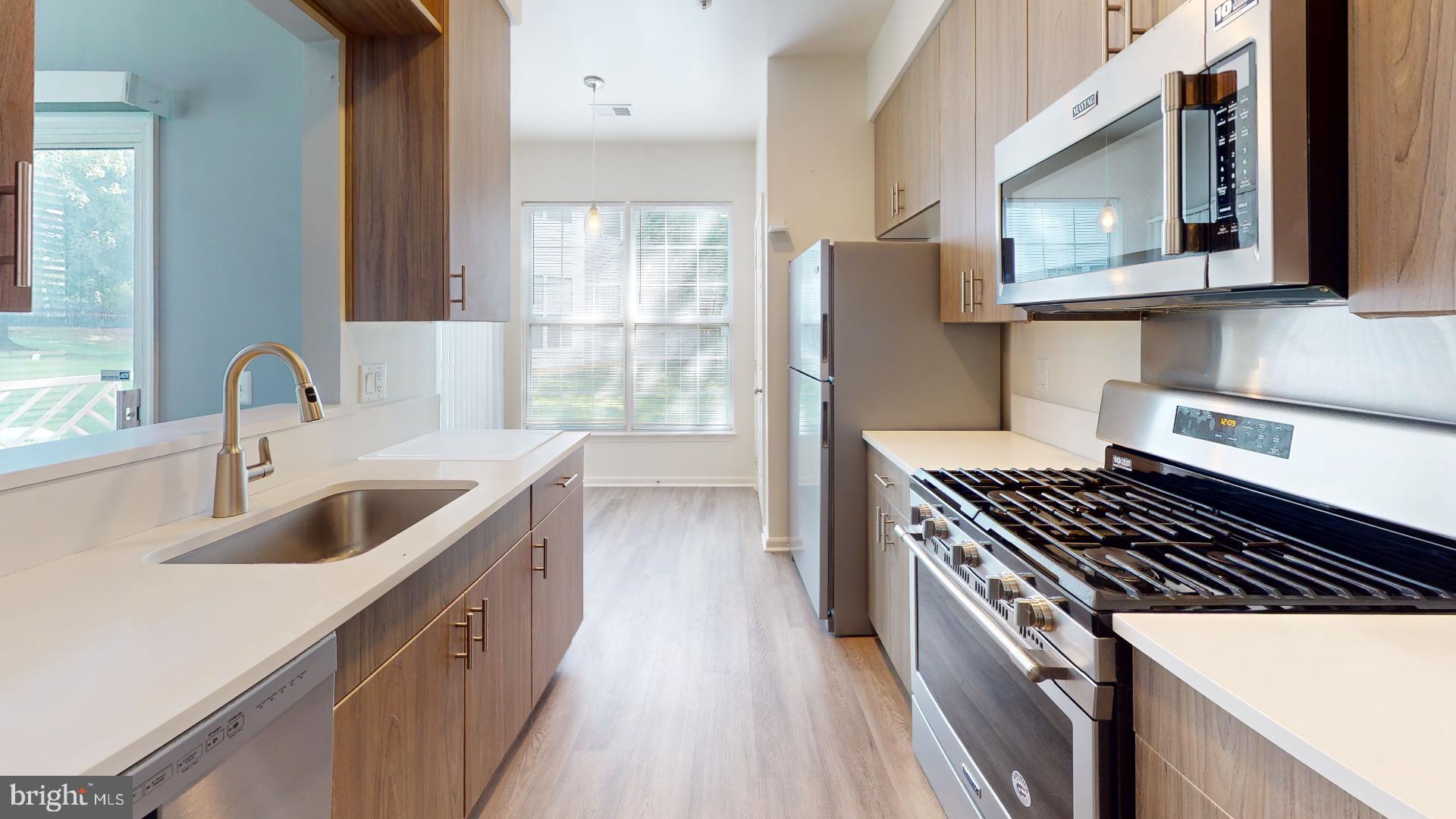 5947 Founders Hill Drive, Unit 103 Alexandria, VA 22310 - Photo 6 of 19 a kitchen that has a sink and a stove