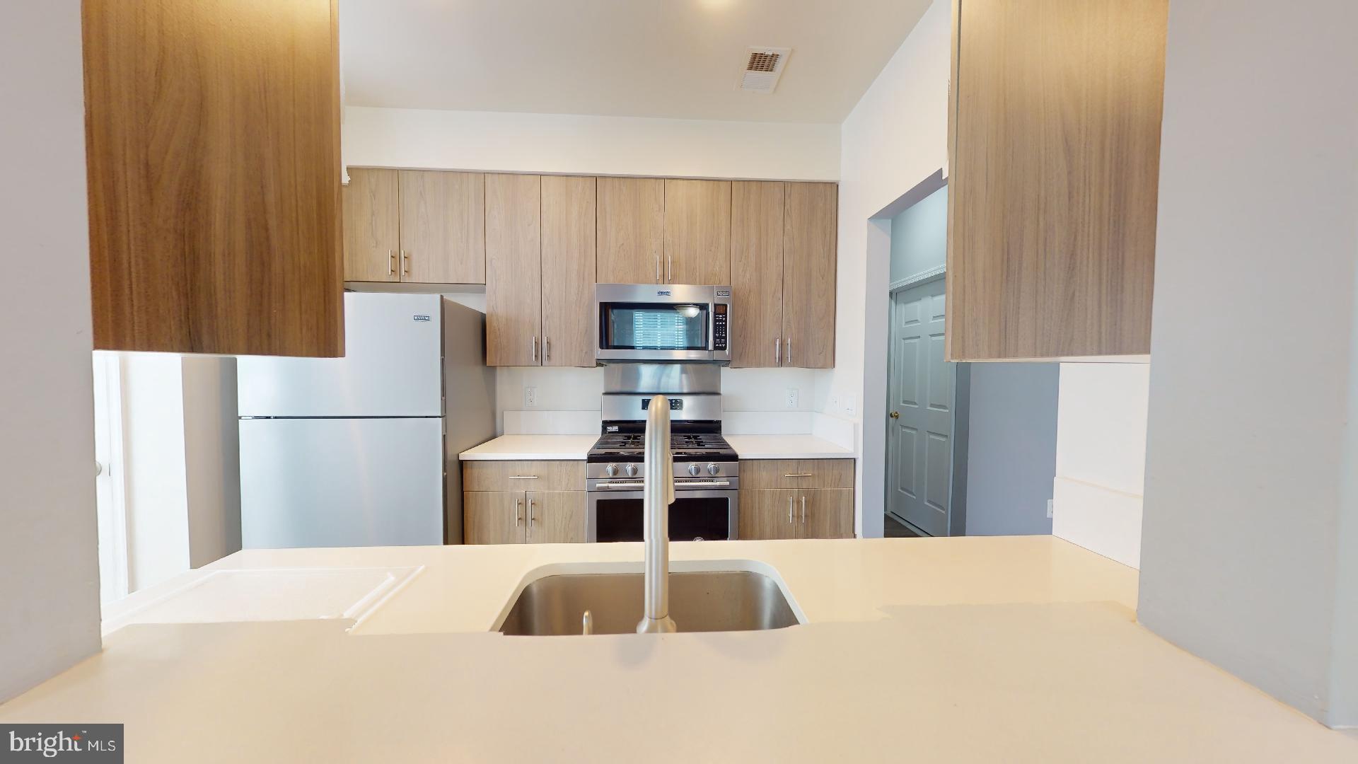 5947 Founders Hill Drive, Unit 103 Alexandria, VA 22310 - Photo 8 of 19 a kitchen with a refrigerator and a stove