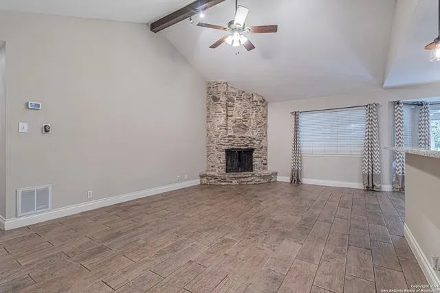 an empty room with a fireplace and fan